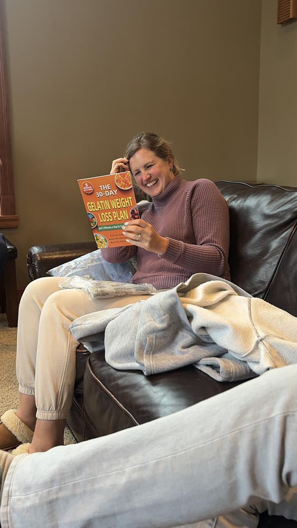 Guest laughing while unwrapping a surprise mystery gift
