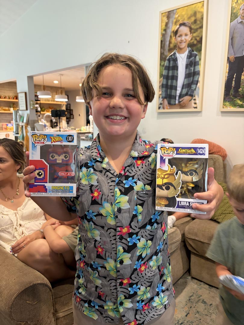 Young guest holding up two mystery collectible figurines