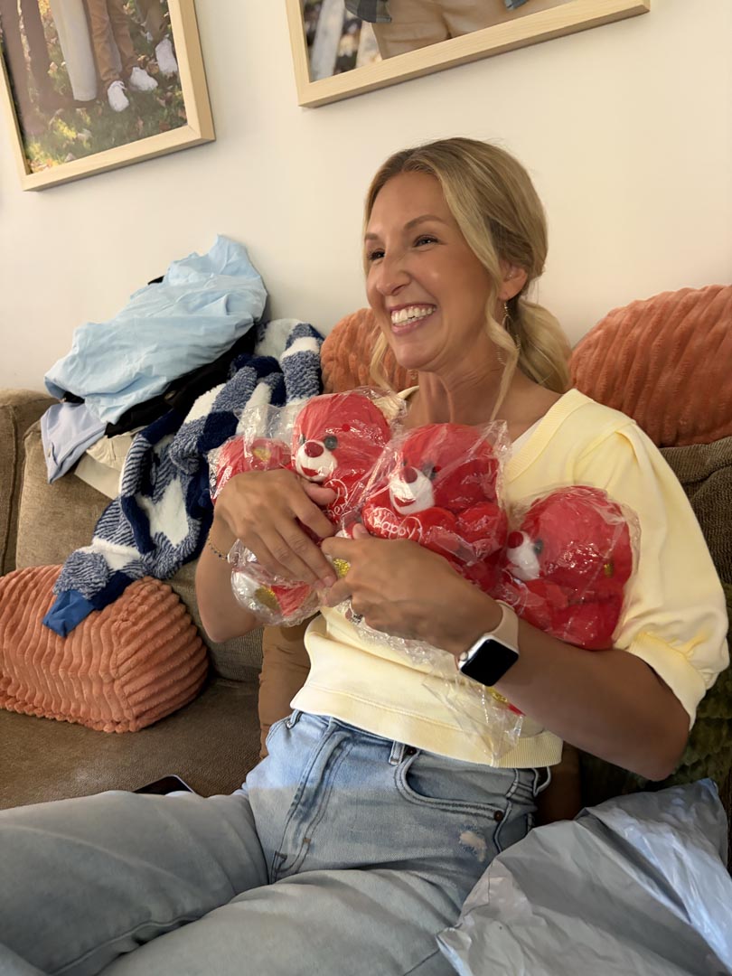 Guest cracking up while holding three plush mystery finds